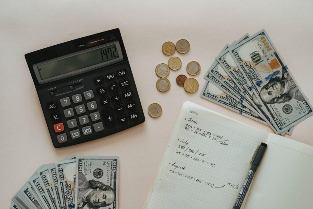 Calculator, money, coins and notebook for budgeting