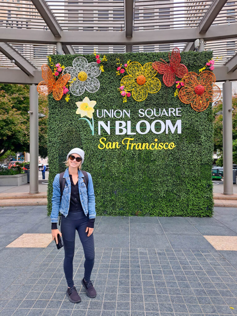 A woman in front of a flower living wall