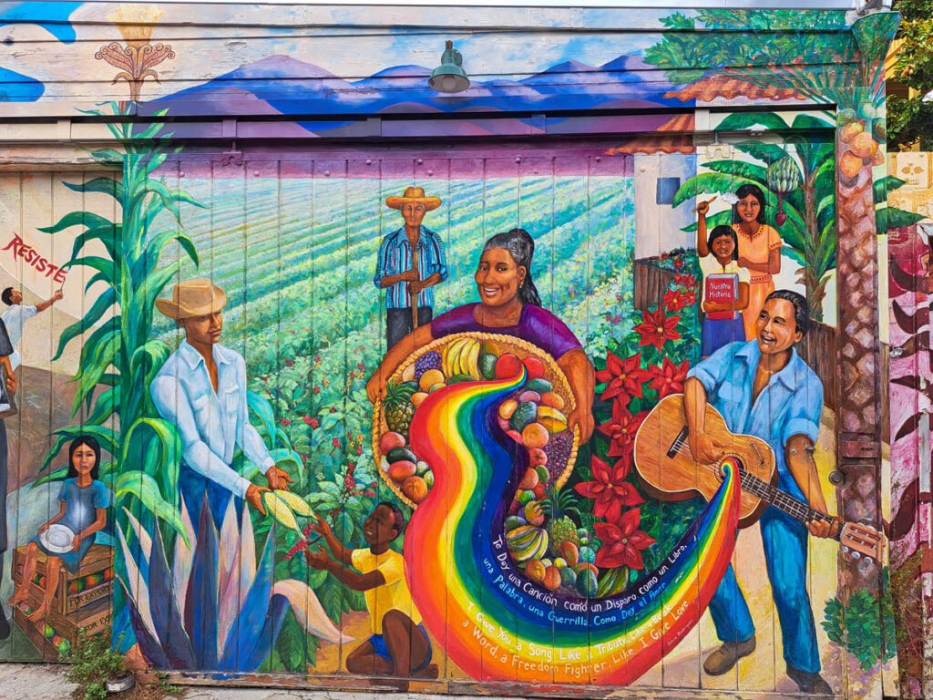 Colorful murals of a farm with rainbow colors, fruit and people in San Francisco's Mission District