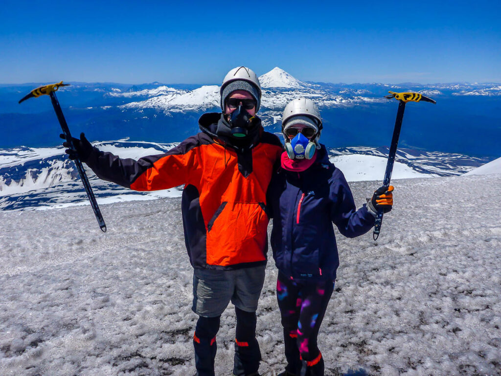 A couple on top of a mountain in Chile with a volcano in the background