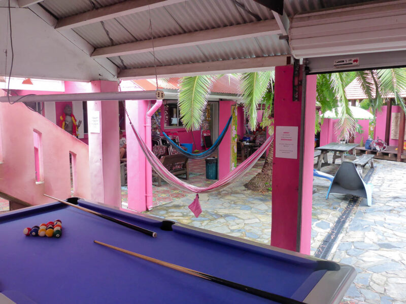 Outdoor pool table, hammocks and picnic table at a pink themed hostel in Australia