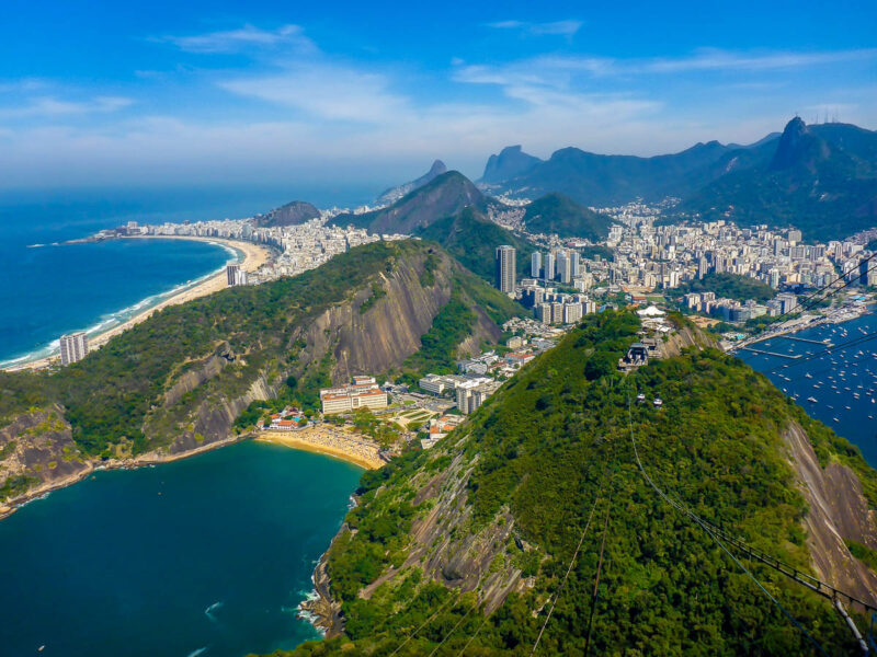 View from Sugarloaf Mountain looking over Rio de Janeiro, Brazil including mountains, hills, the city, ocean and blue skies