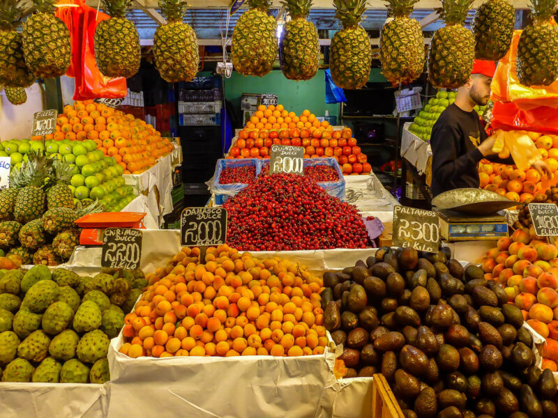 Colorful food market stall with a variety of fruits, vegetables and dried goods. Markets are great to visit for budget travel.