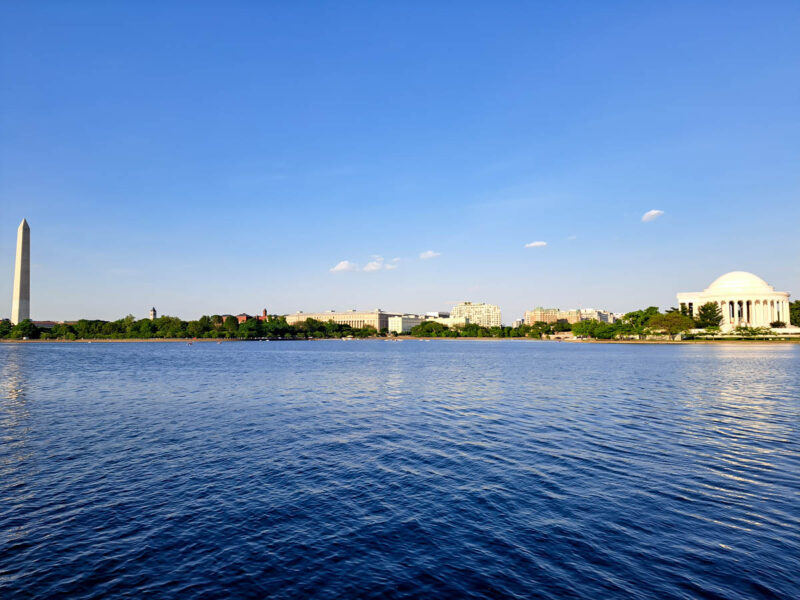 Several monuments in Washington, D.C. from the far side of a lake in front of them.