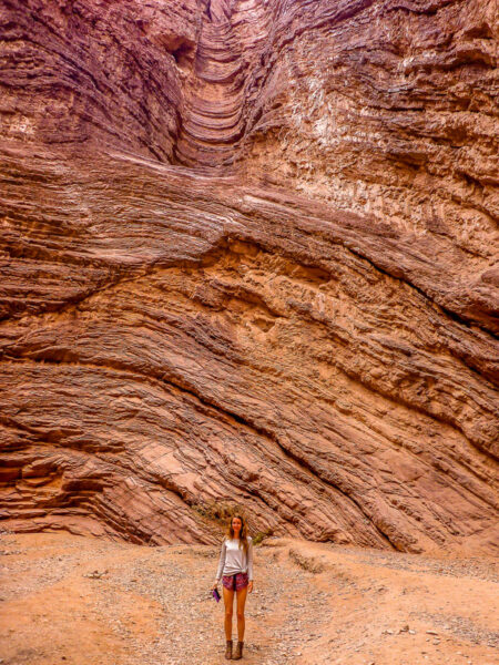 A woman standing in front of a layered rock face in Argentina, South America