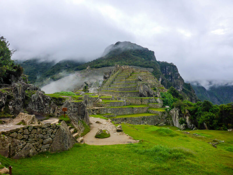 Machu Picchu and ancient ruins in cloudy rainy weather.