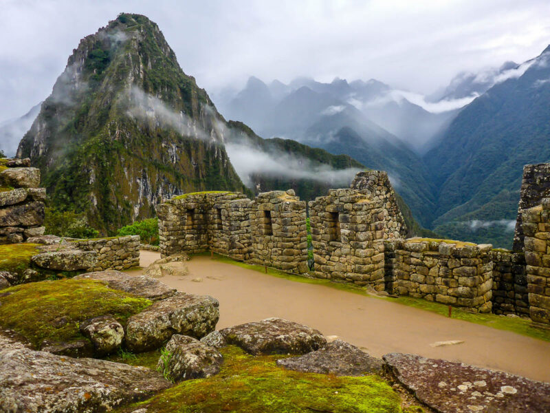 Ancient ruins of Machu Picchu in the Sacred Valley of Peru with the Huayna Picchu mountain in the background. Cloudy and rainy day with low hanging fog and clouds.