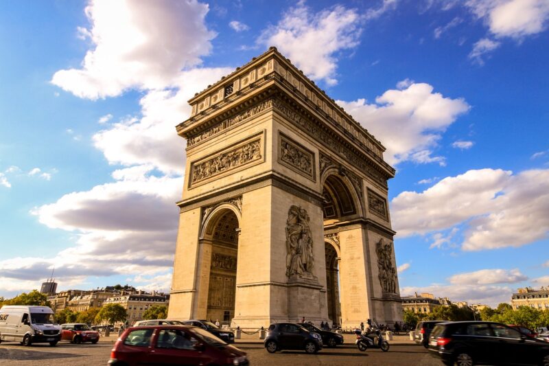 Arc de Triomphe in Paris shining in the sunlight with cars passing by